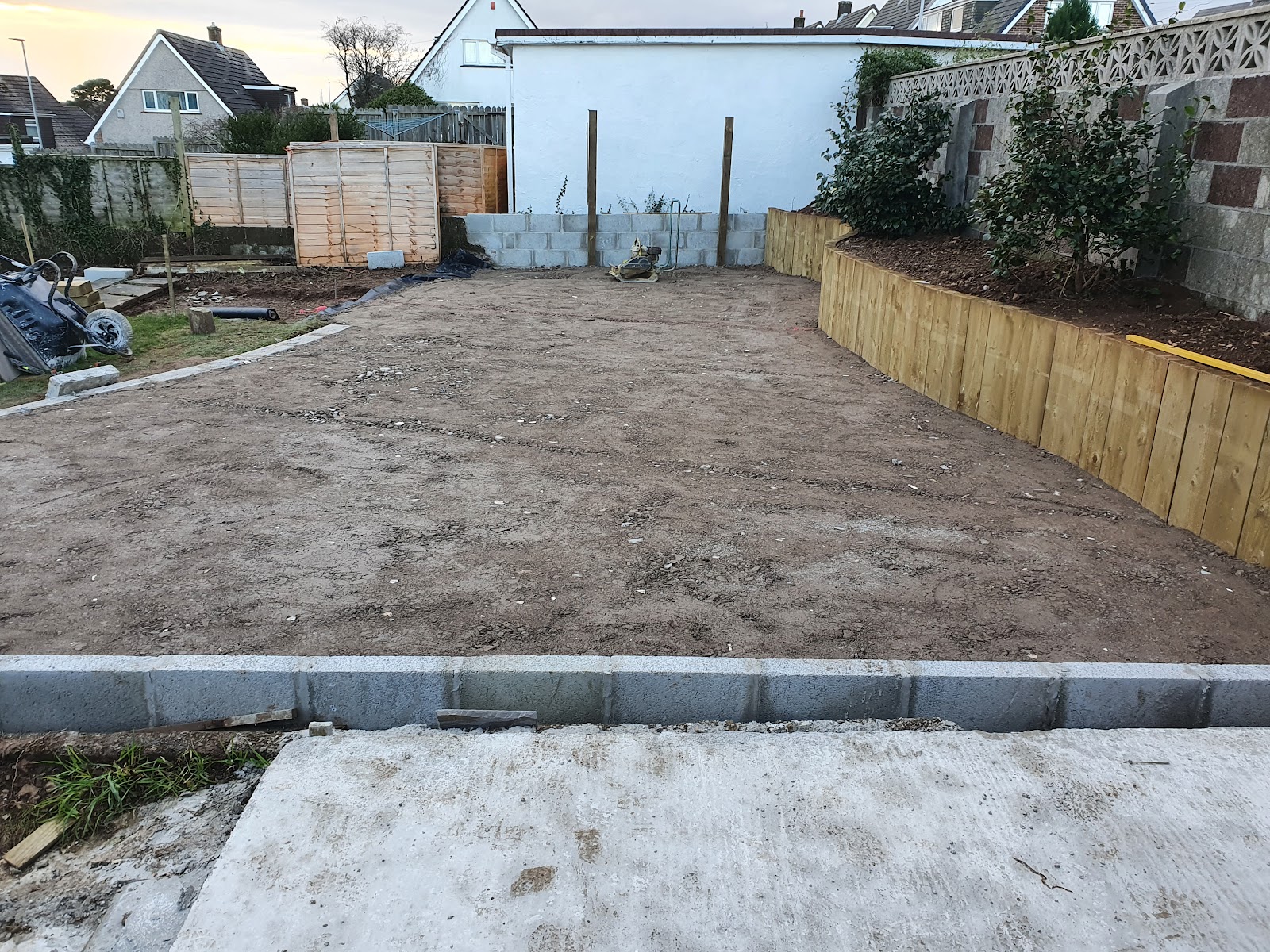 Driveway groundwork with a new sleeper retaining wall and kerb edging